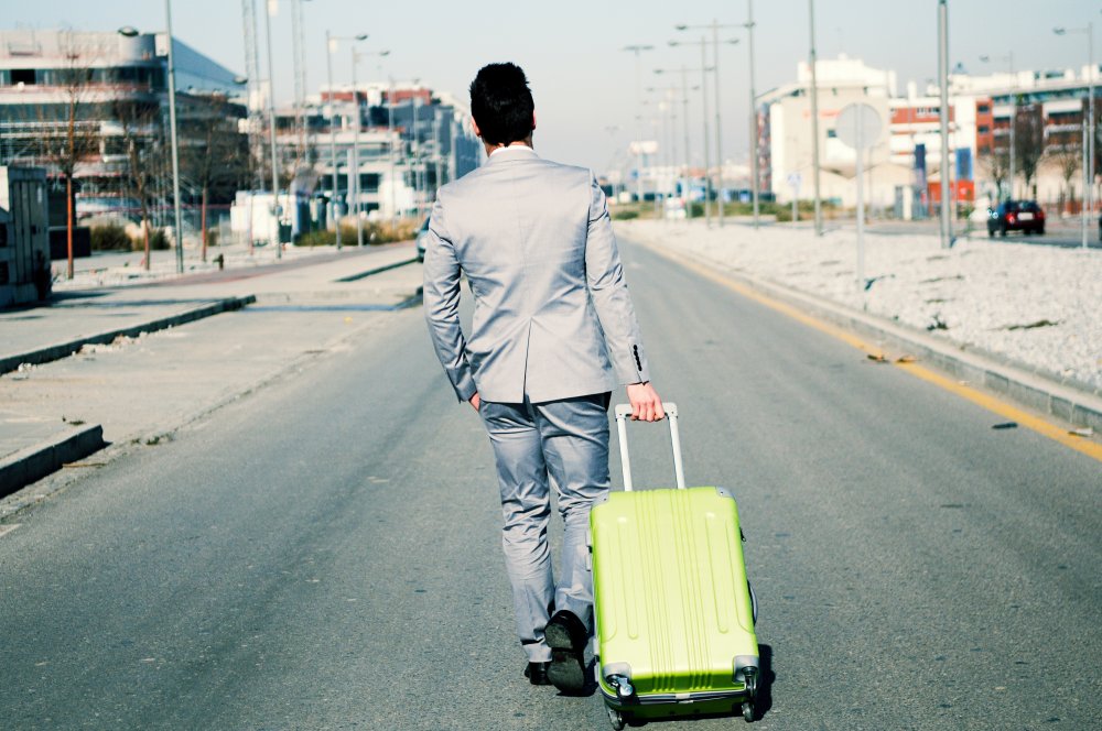 Man dressed in suit and suitcase in the street